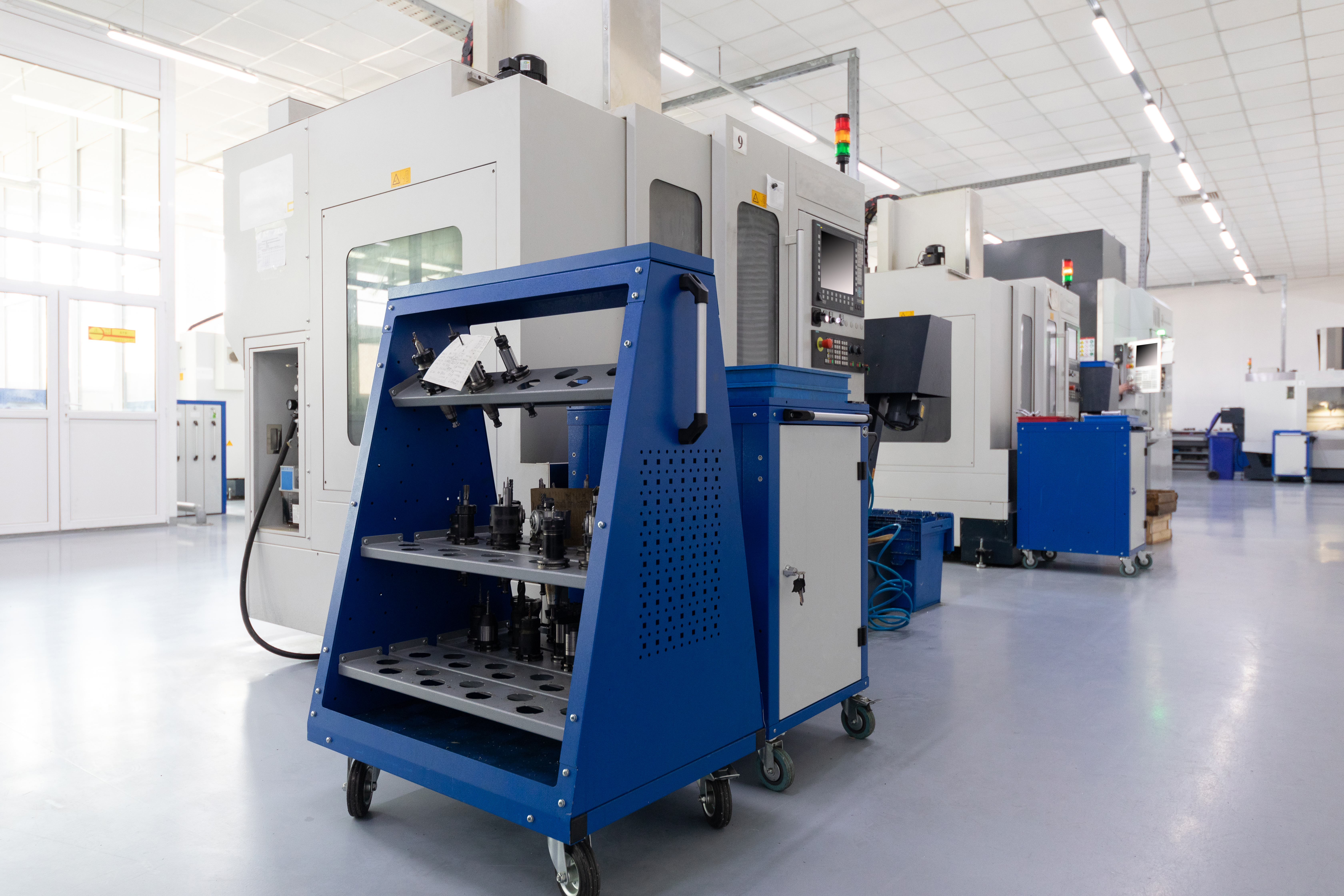 Row of equipment producing metal parts in works. Photo with depth of field